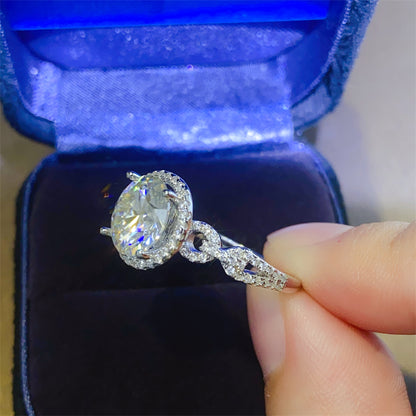 A 925 sterling silver ring with a central moissanite stone surrounded by smaller accent stones, 