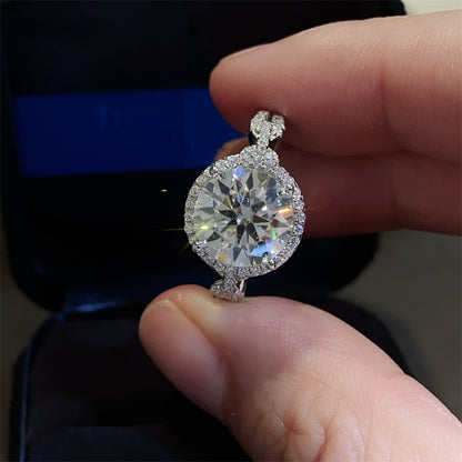 A 925 sterling silver ring with a central moissanite stone surrounded by smaller accent stones, 