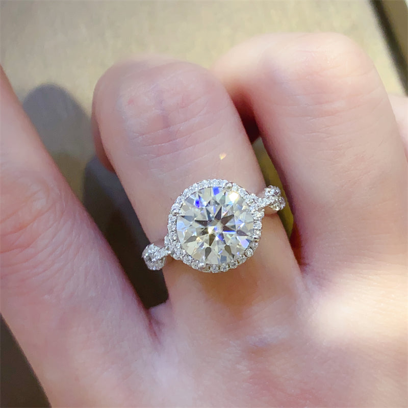 A 925 sterling silver ring with a central moissanite stone surrounded by smaller accent stones, 