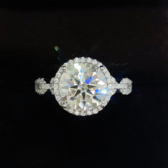 A 925 sterling silver ring with a central moissanite stone surrounded by smaller accent stones, 