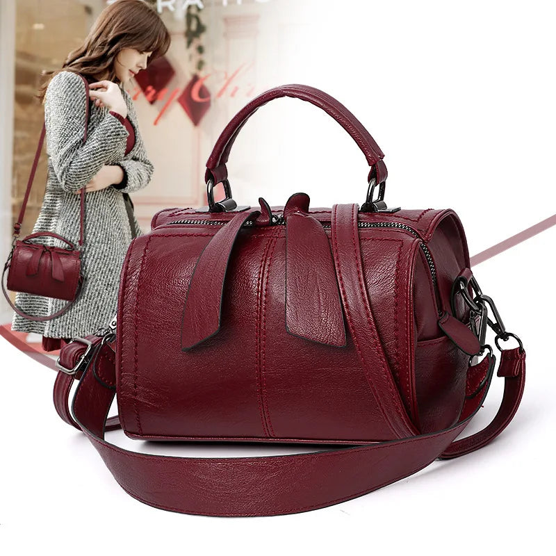 Red handbag with a woman holding a smaller red bag in the background