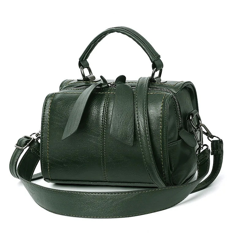 Green leather handbag with a shoulder strap on a white background
