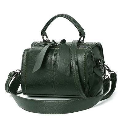 Green leather handbag with a shoulder strap on a white background